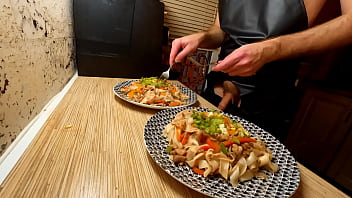 Super-sexy cooking. Bare homo chef is cooking rice noodle with chicken and vegetables